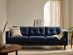 Granatowa sofa welurowa w salonie